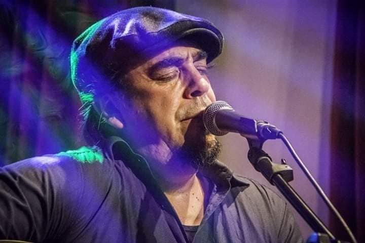 Man in a hat singing into microphone